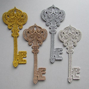 May include: Four ornate key-shaped embroidered patches in gold, silver, and rose gold.