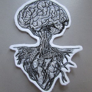 May include: Black and white embroidered patch of a brain connected to a heart. The brain is at the top and the heart is at the bottom. The patch is on a white background.