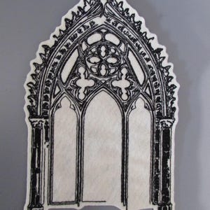 Peut inclure: Applique en feutre noir et blanc en forme de fenêtre de cathédrale gothique. Le motif présente des détails complexes, notamment des fenêtres cintrées, des réseaux décoratifs et un motif de quadrilobe. L'applique est découpée avec un bord festonné.
