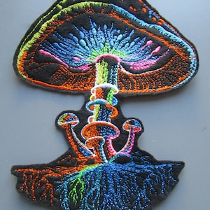 Könnte beinhalten: Ein farbenfroher gestickter Patch mit einem Pilz mit einem großen Hut und einem Stiel, aus dem kleinere Pilze wachsen. Der Pilz ist von Wurzeln umgeben und hat ein psychedelisches Design mit leuchtenden Farben wie Blau, Grün, Orange und Pink.