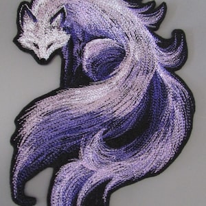 May include: Embroidered patch of a fox in purple and white hues. The design shows a flowing tail and detailed stitching, with a black border. This patch is suitable for attaching to clothing or accessories, adding a decorative element.