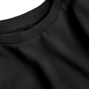 May include: Close-up of a black crew neck t-shirt. The neckline is ribbed and double-stitched. The fabric has a soft texture and subtle diagonal weave. The shirt is a solid black color.