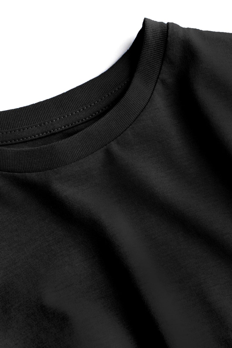 May include: Close-up of a black crew neck t-shirt. The neckline is ribbed and double-stitched. The fabric has a soft texture and subtle diagonal weave. The shirt is a solid black color.