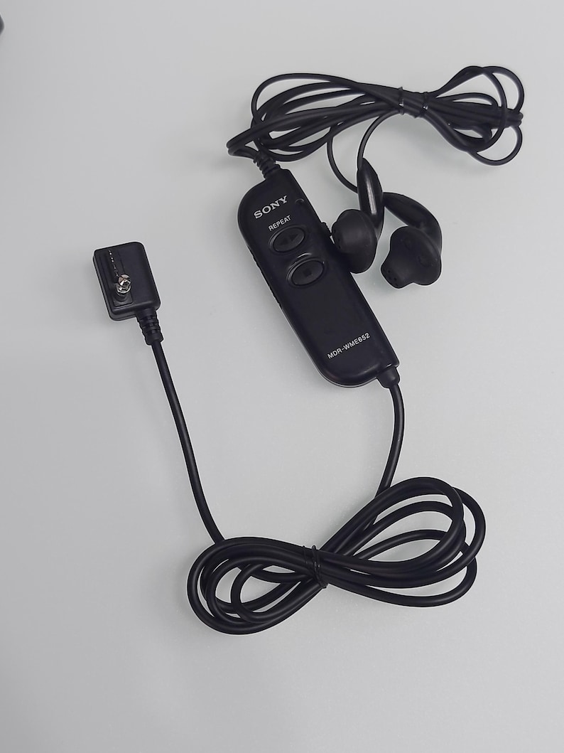 May include: Black Sony MDR-WME652 in-ear headphones with a wired remote control. The headphones have a black cord and earbud design. The remote control has the Sony logo and repeat button.