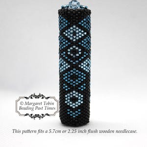 May include: A beaded needle case with a geometric pattern in black and light blue. The case is cylindrical with a crystal-like top. The text on the image says the pattern fits a 5.7cm flush wooden needlecase.