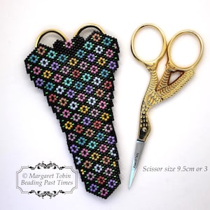 May include: A black beaded scissor case with a floral pattern in shades of pink, blue, green, and yellow. The case is designed to hold a pair of gold-coloured scissors, which are 9.5 cm or 3 1/2 inches long.