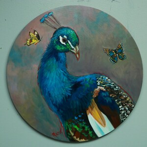 May include: A blue peacock with a long neck and tail feathers is painted on a round canvas. The peacock is facing the left side of the image. Two yellow butterflies are painted on the canvas, one above the peacock's head and one to the right of the peacock's tail.