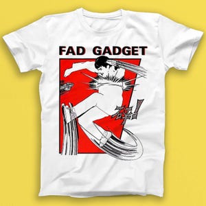 May include: White t-shirt featuring the text "FAD GADGET" above a red square with a black and white manga-style illustration of a figure in motion. The graphic includes motion lines and Japanese text.