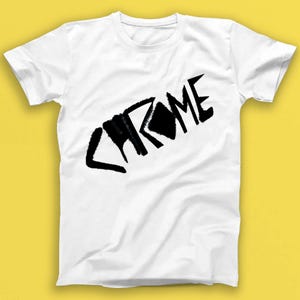May include: White t-shirt with a black graphic of the word "CHROME" in a stylized, graffiti-like font.