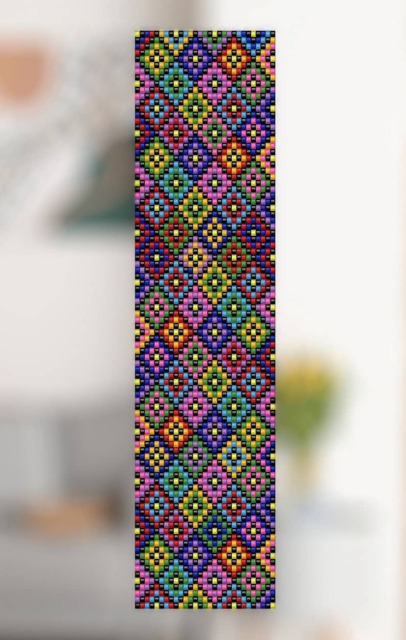 Op de afbeelding: Een lange, rechthoekige kralenstrook met een herhalend geometrisch ruitpatroon. Het ontwerp is samengesteld uit kleine, levendige kralen in tinten blauw, groen, geel, oranje, roze en paars, allemaal omlijnd door een consistente zwarte kralenrand.