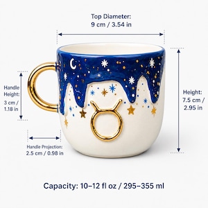 May include: A white ceramic mug featuring a gold Taurus zodiac symbol and a blue drip-style rim with gold and white stars. It has a gold handle, a 3.54 inch top diameter, 2.95 inch height, 1.18 inch handle height, 0.98 inch projection, and 10-12 fl oz capacity.