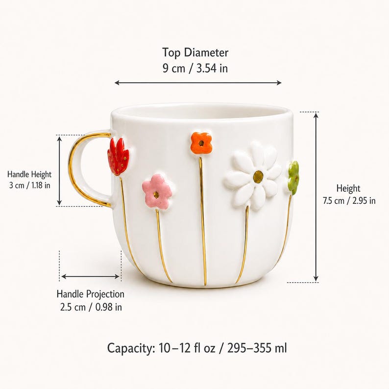 May include: White ceramic mug with colorful 3D flower accents and a gold handle. The mug has a top diameter of 3.54 inches, a height of 2.95 inches, and a capacity of 10-12 fl oz.