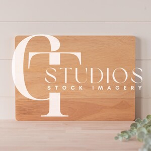 May include: A wooden sign with the text "STUDIOS STOCK IMAGERY" in white lettering. The sign is light brown and has a natural wood grain.
