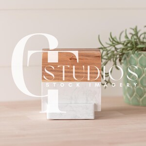 May include: A wooden and white marble tiered stand with the text "STUDIOS STOCK IMAGERY" on the top tier.