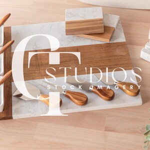 May include: A wooden and marble cheese board with four small white bowls and spoons, five cheese knives, and the text "STUDIOS STOCK IMAGERY".