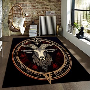 May include: Black and gold rug with a circular design featuring a goat's head with horns and a pentagram. The goat's head is in the center of the circle, and the pentagram is above it. The circle is surrounded by a gold border with a black background.