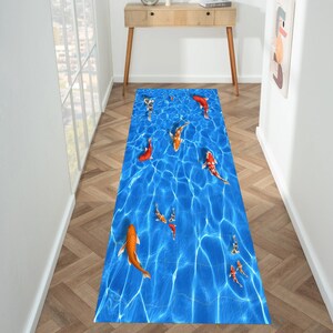 Puede incluir: Una alfombra azul y blanca con un patrón de peces koi nadando en un estanque. La alfombra tiene un diseño realista y es perfecta para agregar un toque de naturaleza a cualquier habitación.