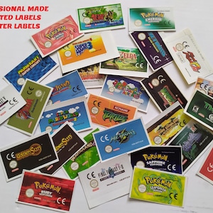 May include: A collection of colorful, laminated game labels featuring various titles like Pokémon, Super Mario, and Zelda. The labels are precut and professionally made, with text including game names and the CE mark.