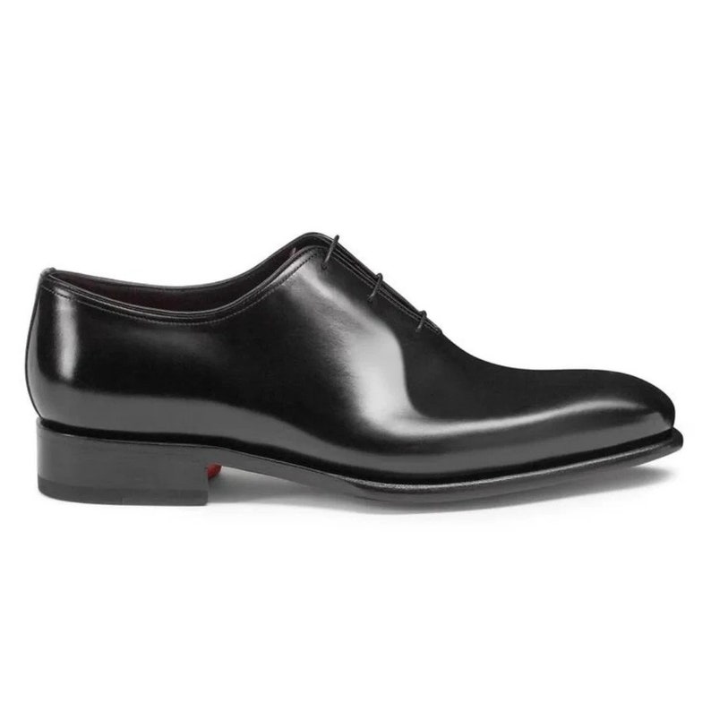 Op de afbeelding: Zwarte leren veterschoenen met een spitse neus en een gepolijste afwerking.