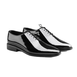 May include: A pair of black leather lace-up shoes with a polished finish.