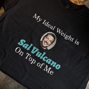 May include: Black t-shirt with white text that reads "My Ideal Weight is Sal Vulcano On Top of Me". A photo of Sal Vulcano is in a circle above the text.