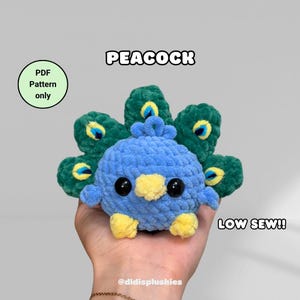 Può includere: Un pavone all'uncinetto blu e giallo fatto a mano con la coda verde. Il peluche ha occhi neri e piedi gialli. Il testo sull'immagine recita "PEACOCK" e "LOW SEW!!". Una grafica circolare recita "PDF Pattern only".