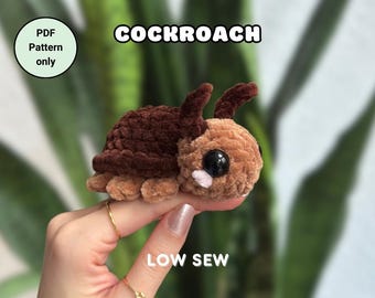 May include: A brown and tan crocheted cockroach plush toy with large black eyes. The toy is being held by a hand with gold rings. The text "COCKROACH" is above the toy and "LOW SEW" is below the toy. The text "PDF Pattern only" is in a circle in the top left corner of the image. The text "@didisplushies" is below the toy.