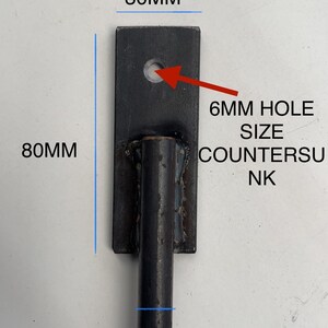 May include: Black metal bracket with a 6 mm hole. The bracket is 30 mm wide, 80 mm tall, and has a 12 mm diameter rod attached.  6MM HOLE SIZE COUNTERSUNK