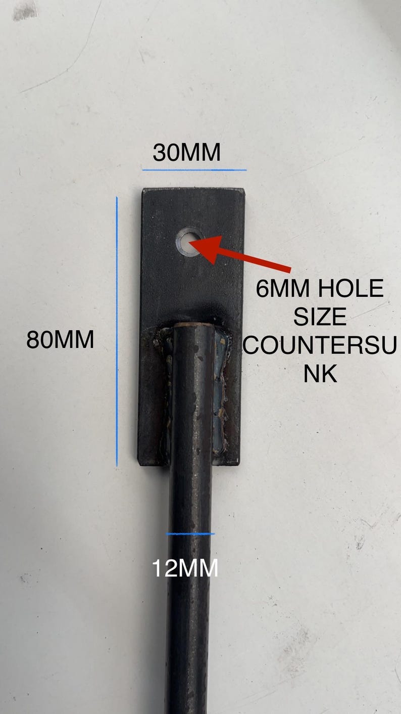May include: Black metal bracket with a 6 mm hole. The bracket is 30 mm wide, 80 mm tall, and has a 12 mm diameter rod attached.  6MM HOLE SIZE COUNTERSUNK
