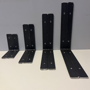 May include: Five sets of black metal shelf brackets in different sizes. The brackets are L-shaped and have multiple holes for fixing.