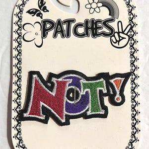 May include: An iron-on embroidered patch on a display card featuring the word NOT! in multi-colored letters. The N is red, the O is purple, the T is green, and the exclamation point is orange, all outlined in black thread.