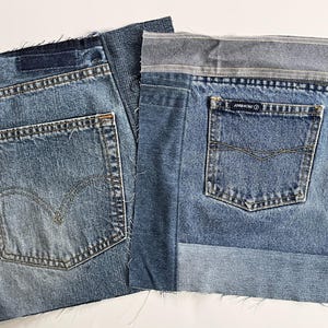 May include: Two square patches of blue denim fabric. The left patch features a back pocket with a red tab and arcuate stitching. The right patch includes a back pocket with a label reading Jordache and a horizontal waistband strip at the top.