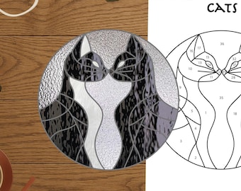 Puede incluir: Un diseño de gato para vidrieras en blanco y negro, junto con un patrón impreso "CATS" para un proyecto de vidrieras. También hay herramientas como alicates, cinta adhesiva y un cortador de vidrio.