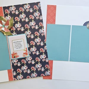 May include: Two scrapbook pages with a teal and white color scheme. One page has a floral patterned paper and a pinwheel. The other page has a decorative button. Text on a card reads: "A grandparent is so easy to operate even a child can do it."