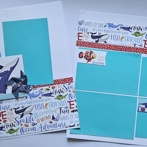 May include: Two scrapbook pages with a sea life theme. One page has two turquoise photo mats, a whale illustration, and a pinwheel. The other page has four turquoise photo mats and stickers that say "Sharks" and "Just Keep Swimming".