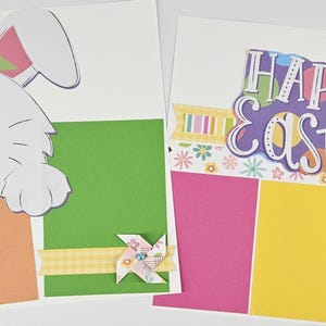 May include: A handmade wooden sign with the text "Welcome" in a playful font. The sign is painted white with a distressed finish, and features a decorative floral design in shades of pink and green. It measures approximately 12 inches wide and 6 inches tall.