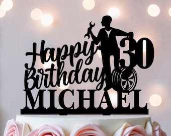 Peut inclure: Décoration de gâteau noire avec l'inscription "Happy Birthday MICHAEL" et le chiffre "30". La décoration représente une silhouette d'une personne tenant une clé et se tenant à côté d'un pneu. Le gâteau est décoré de roses roses.