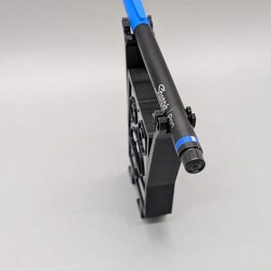 Puede incluir: Un portal&aacute;pices negro con un bol&iacute;grafo Sharpie azul. El bol&iacute;grafo es negro con detalles azules y el texto "Sharpie Pen" impreso en el lateral. El portal&aacute;pices es negro y tiene un dise&ntilde;o geom&eacute;trico.