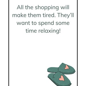 May include: A white card with a black border and green text that reads "All the shopping will make them tired. They'll want to spend some time relaxing!"  Two green slippers with pink hearts are in the bottom right corner of the card.