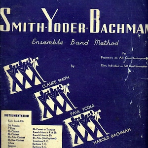 May include: A vintage blue book cover with white text that reads "Start Your Band with Smith-Yoder-Bachman Ensemble Band Method". The cover features three illustrations of marching band members with instruments, each labeled with the names "Claude Smith", "Paul Yoder", and "Harold Bachman".