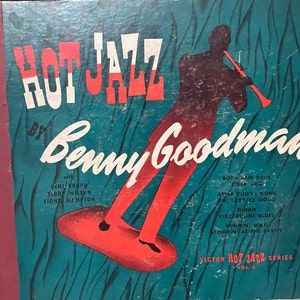 Op de afbeelding: Een vintage platenhoes met een silhouet van een man die klarinet speelt. Het album is getiteld "Hot Jazz by Benny Goodman" met de tekst "Victor Hot Jazz Series Vol. II" onderaan. De hoes is een levendig turquoise blauw met rode en witte accenten.