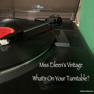 Może przedstawiać: Czarny gramofon z płytą na nim i ramieniem. Tekst "Miss Eileen's Vintage What's On Your Turntable?" znajduje się na gramofonie. Tekst "Eileen Patterson" znajduje się na dole obrazu.
