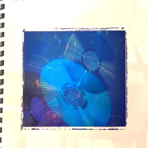May include: A spiral-bound music book titled "Pop Ballads" from The Phillip Keveren Series for Easy Piano. The cover features a blue design with musical notes and CDs. The publisher's logo is at the bottom.