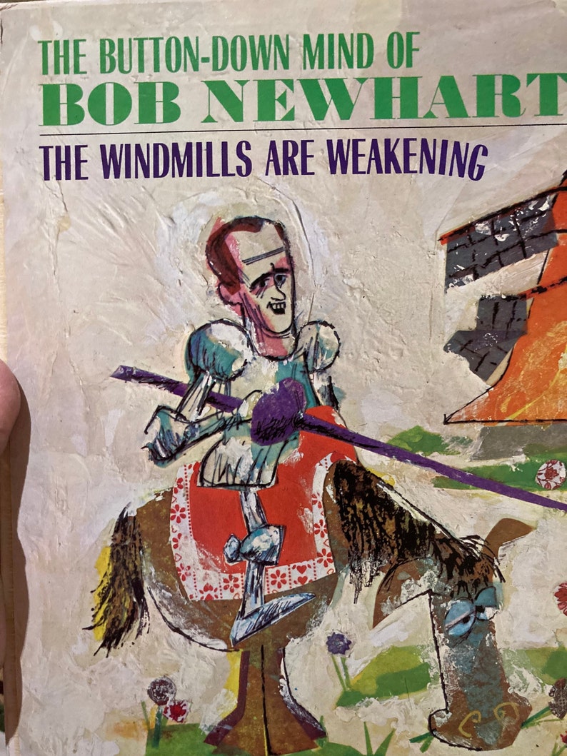 Może przedstawiać: Okładka starej książki z kolorową ilustracją mężczyzny na koniu. Tytuł książki to "The Button-Down Mind of Bob Newhart: The Windmills Are Weakening."