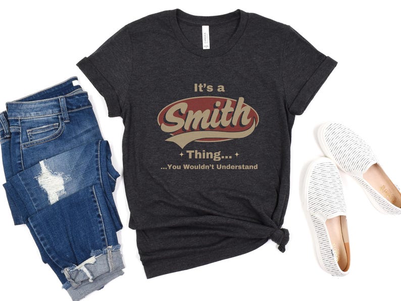 May include: A dark gray t-shirt with a red and white vintage-style logo that says "It's a Smith Thing... You Wouldn't Understand".