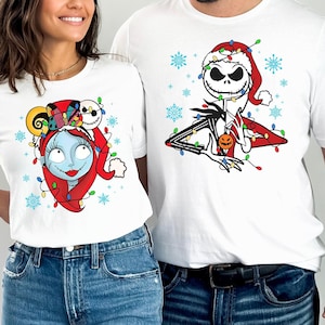 Pu&ograve; includere: Una maglietta bianca con una grafica natalizia di Jack Skellington di The Nightmare Before Christmas. La grafica presenta Jack Skellington con un cappello da Babbo Natale e circondato da luci natalizie. La maglietta &egrave; indossata da una persona.