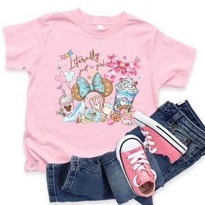 May include: A pink t-shirt with the text "Literally just a girl" and a graphic of a Minnie Mouse bow, desserts, and shoes. Paired with blue denim jeans and pink sneakers.
