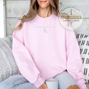 May include: A pink sweatshirt with the text "we do not meet all the time" embroidered on the front.