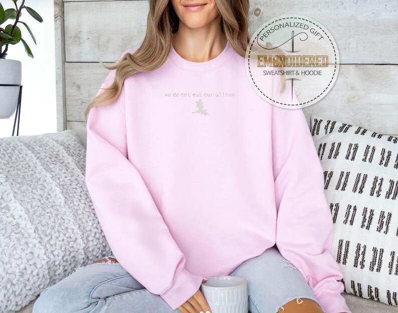 May include: A pink sweatshirt with the text "we do not meet all the time" embroidered on the front.