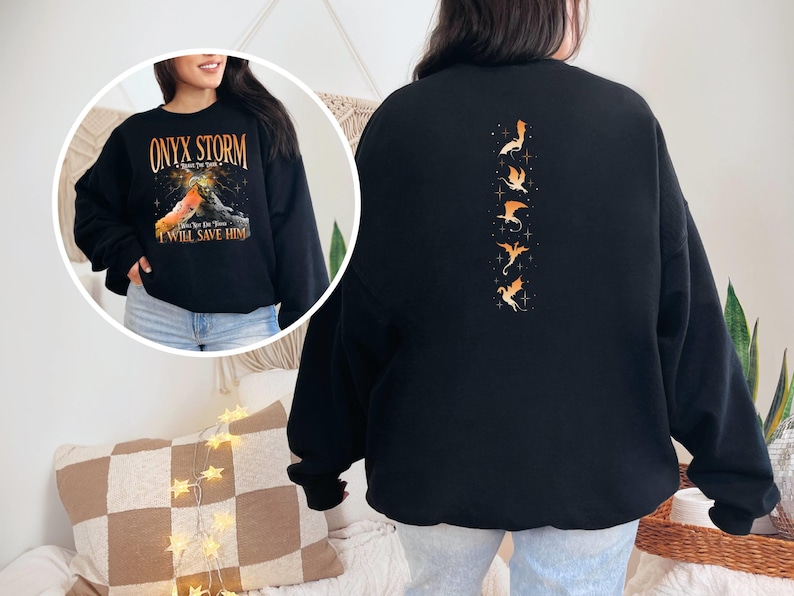May include: Black sweatshirt with a graphic of a dragon on the front and a row of dragons on the back. The text on the front reads "Onyx Storm - Rise to the Stars - I Will Save Him".